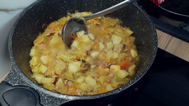 Traditional cabbage soup with sausages and vegetables