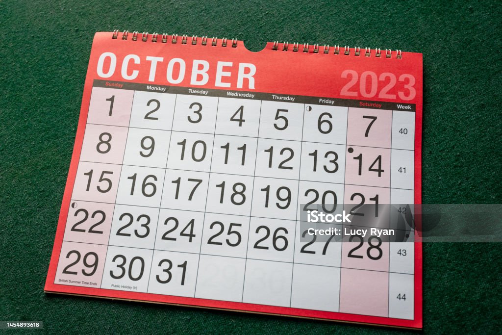 Calendar 2023, October, monthly planner for wall and desk. Calendar 2023, October, monthly planner. Day, month, year, date and activity organiser wall and desk planner. Red and white calendar with large letters and numbers on green background. Shown at angle. 2023 Stock Photo