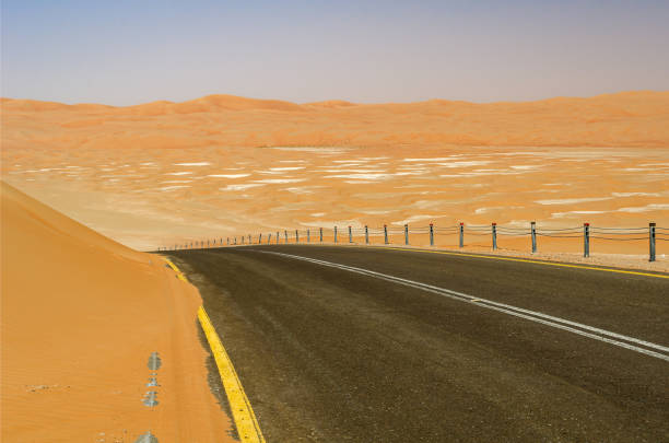 strada del deserto ad abu dhabi - arid climate asphalt barren blue foto e immagini stock