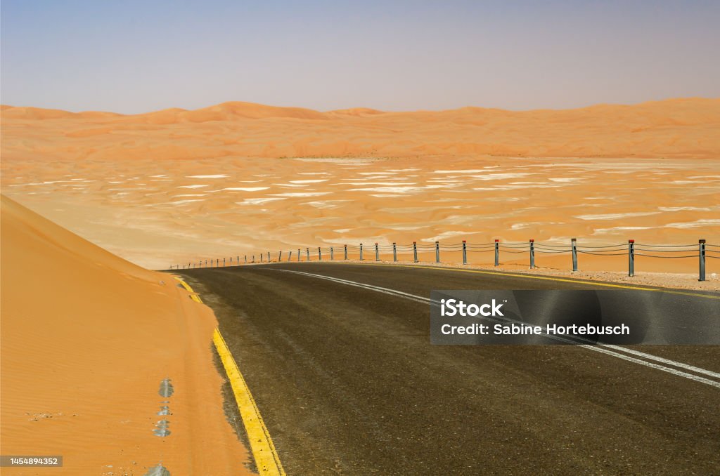 Desert Road in Abu Dhabi Desert Road in Abu Dhabi, in the Liwa Desert which is part of the Rub al Khali Desert or Empty Quarter desert, straddling UAE, Oman, Yemen and Saudi Arabia Abu Dhabi Stock Photo