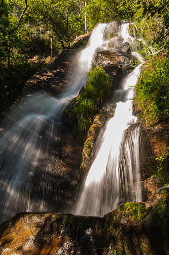 Beautiful water stream in Filveda waterfall, Sever do Vouga, Portugal. Long exposure smooth effect. Idyllic green scenery, mountain forest landscape.