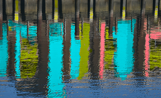 This abstract image features afternoon reflections of a seaside wharf in Newport Beach, California.
