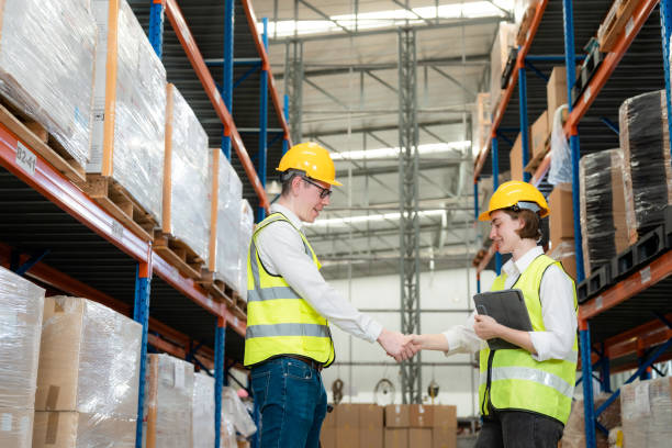 istock Engineers are working together with smiles in a large warehouse. 1454909733