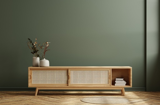 Modern interior of living room with cabinet for tv on dark green color wall background.