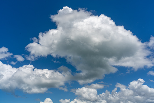 Cumulus clouds appear in a blue sky over Walnut Canyon Lakes in Flagstaff, Arizona, USA.