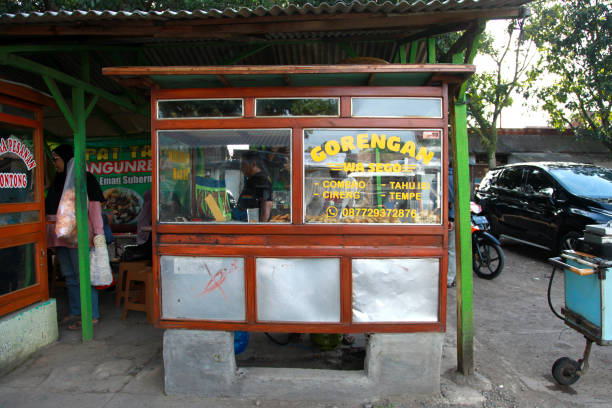 Indonesian street food vendor selling freshly deep-fried Gorengan including Tahu Isi, Tempe Goreng, Tahu Isi, Cireng and Combro from a market stall in Bandung, West Java, Indonesia. Indonesian street food vendor selling freshly deep-fried Gorengan or deep fried snacks including Tahu Isi or stuffed tofu, Tempe Goreng or deep fried tempeh, Cireng and Combro from a market stall in Bandung, West Java, Indonesia. gorengan stock pictures, royalty-free photos & images