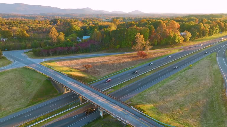 View from above of busy american highway with fast moving traffic between evening autumn woods in South Carolina. Interstate transportation concept