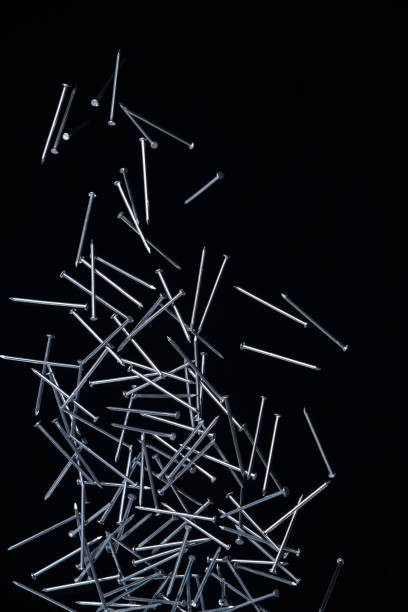 istock Long Nail fly floating in mid air. Many group screw nails short long metal fall as construction tools. Black background isolated. New Screwdriver Nail fall down unbox steel hardware work 1454920263
