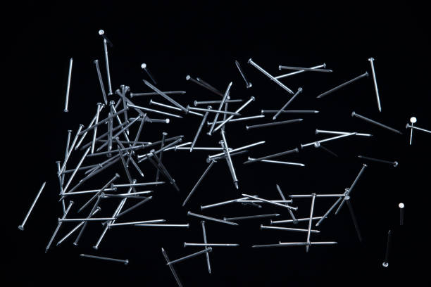 istock Long Nail fly floating in mid air. Many group screw nails short long metal fall as construction tools. Black background isolated. New Screwdriver Nail fall down unbox steel hardware work 1454920274