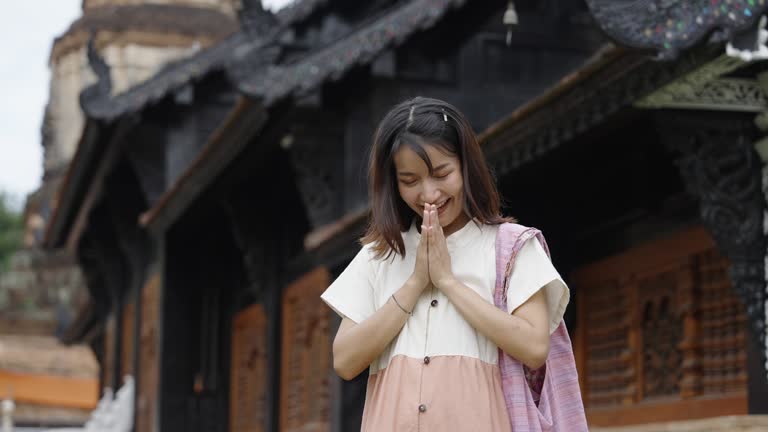 One pretty girl doing a Thai traditional Greeting at the temple