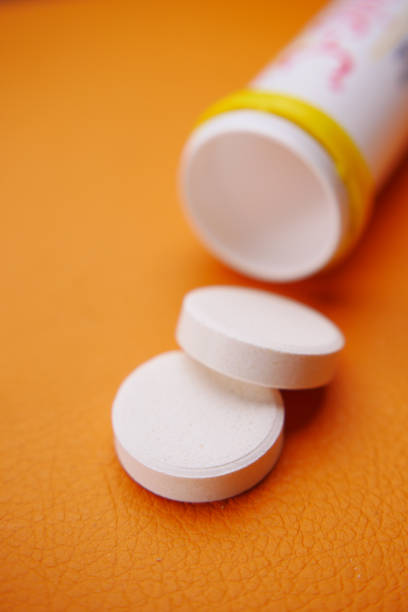 istock Effervescent soluble tablet pills on orange purple background 1454921070