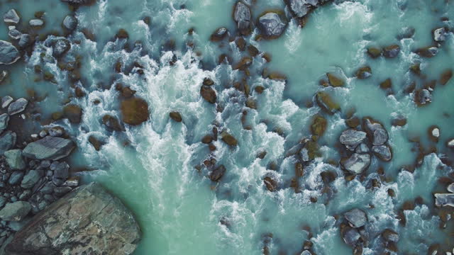 Top down view of rushing glacial river of snowmelt with rocks and whitewater