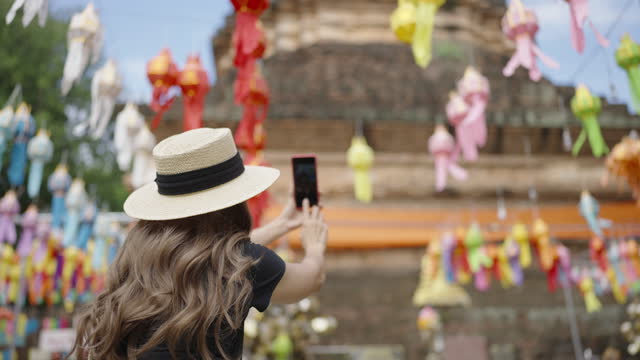 One tourist woman taking pictures of the historical temple Jaedee with lantern.