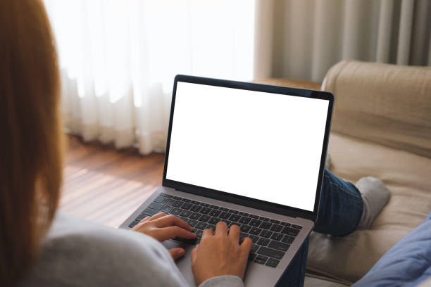 istock Mockup image of a woman working and typing on laptop computer with blank screen on sofa at home 1454924332