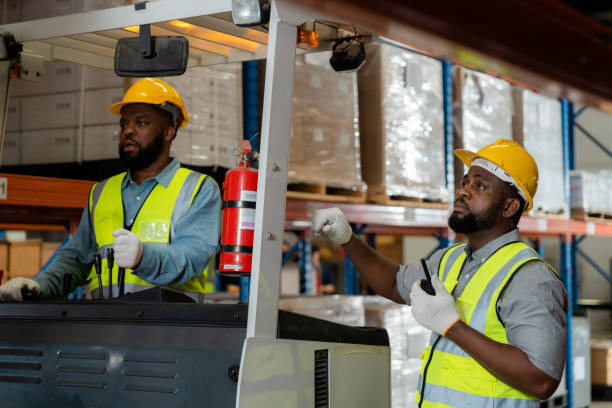 istock Two African workers working in a warehouse Organize the product system with a forklift truck. transportation industry. 1454924359