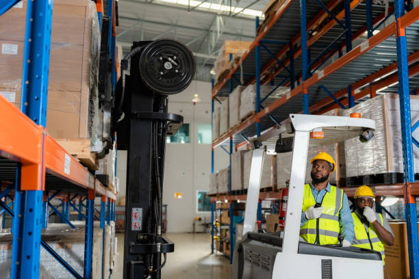 istock Two african workers talking working in a warehouse Organize the product system with a forklift truck. 1454924383