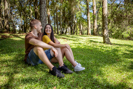 Young couple sitting on grass in city park