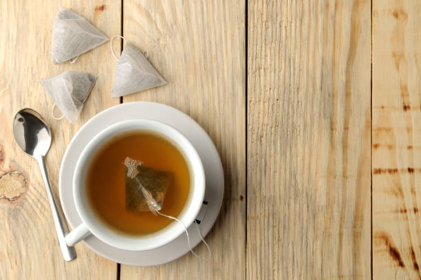 istock cup with tea and tea bag pyramid. close-up. on a wooden table. to make tea 1454927671