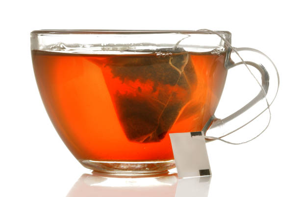 istock glass cup with tea and tea bag close up on white isolated background 1454927687