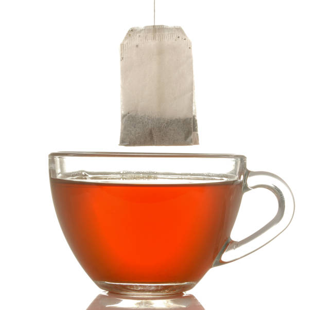 istock glass cup with tea and tea bag close up on white isolated background 1454927693