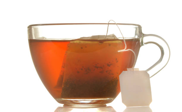 istock glass cup with tea and tea bag close up on white isolated background 1454927696