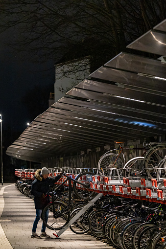 Copenhagen, Denmark Dec 13, 2022 A person lifts a bicyle onto a bicycle parking rack in the Norrebro district at the train station.