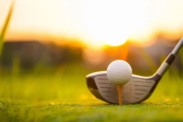 Photo of Golf clubs and golf balls on a green lawn in a beautiful golf course.