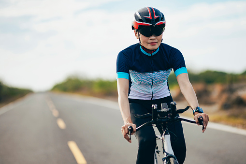Female triathlete cycling on country road
