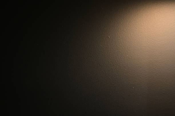 istock brown wall background with lights and black shadow 1454932304