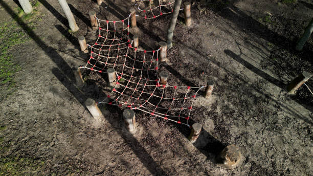 the rope net is attached to the tree through soft items protecting the bark. children can play sailors and test stability like spiders. they crawl and climb among the trees in the park. slack line
