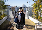 Portrait of high school girl standing in public park