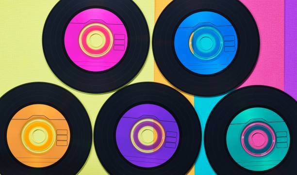 istock Colorful vinyl CD discs in flat lay format displayed on a multicolored background. 1454940377