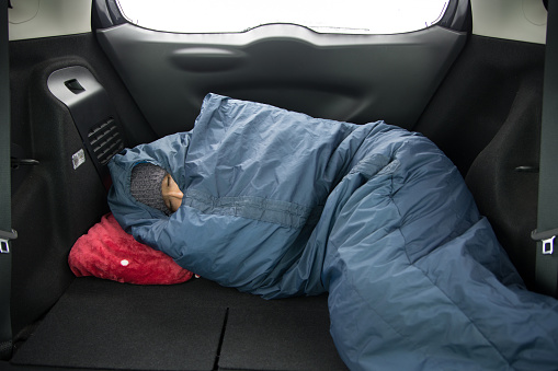 man is sleeping in car