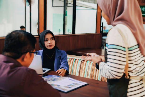 istock Beautiful waitress at cafe taking order from customers 1454940744