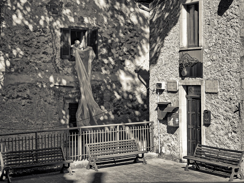 The Abruzzo region in Italy on June  01, 2022:  Elderly man hanging laundry out of his apartment window in the Town of Scanno in the Abruzzo countryside of Italy