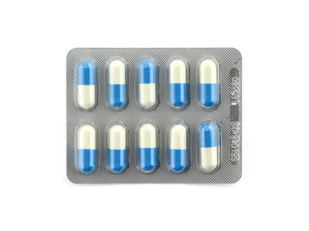 pacchetto di capsule pillole blu e bianche isolate su sfondo bianco - blister packaging foto e immagini stock