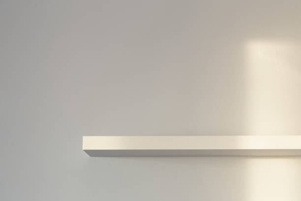istock background of wooden shelf on white wall in sunlight 1454946799