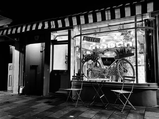 Quaint entrance to the Mooch Hairdresser in Brighton, England. Captured on the 9th January 2023. Big window with logo and an old rustic bike on display