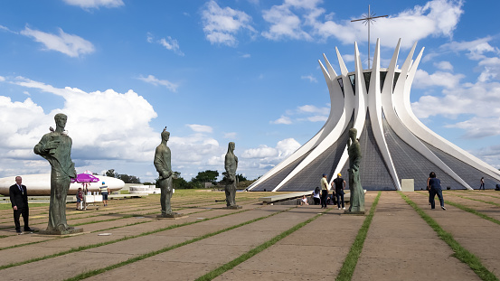 Brasilia, Brazil – May 2019 – Architectural detail of The Cathedral of Brasilia, officially the Metropolitan Cathedral of Our Lady of Aparecida (Catedral Metropolitana Nossa Senhora Aparecida), dedicated to the Blessed Virgin Mary under her title of Our Lady of Aparecida, proclaimed by the Church as Queen and Patroness of Brazil. \nThis Roman Catholic cathedral was designed by Brazilian architect Oscar Niemeyer and calculated by Brazilian structural engineer Joaquim Cardozo and it was completed and dedicated on May 31, 1970.\nThe cathedral is a hyperboloid structure constructed from 16 concrete columns, weighing 90 tons each (source: Wikipedia)