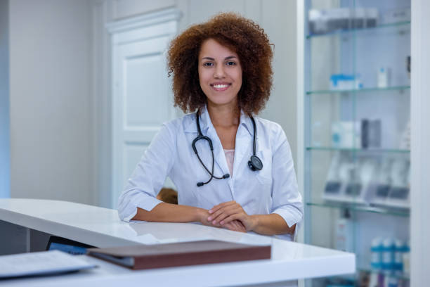 istock Smiling friendly female doctor sitting at the table 1454953908