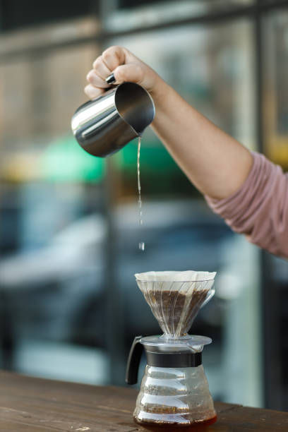Brewing coffee in a funnel. Pour over Coffee In Funnel. Alternative Method. Beautiful table with dark background. The process of brewing the coffee specialty.