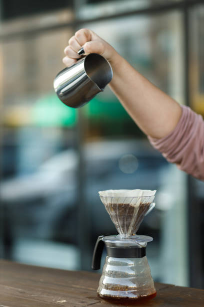 istock Brewing coffee in a funnel. Pour over Coffee In Funnel. Alternative Method. Beautiful table with dark background. The process of brewing the coffee specialty. 1454958311
