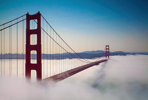 The gradient blue sky over the red Golden Gate Bridge, San Francisco on a foggy evening