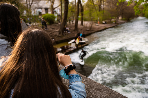 Women watching surfers on the Eisbach river in Munich