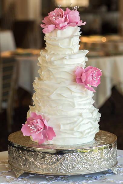 istock White ruffled wedding cake with edible flowers 1454963780