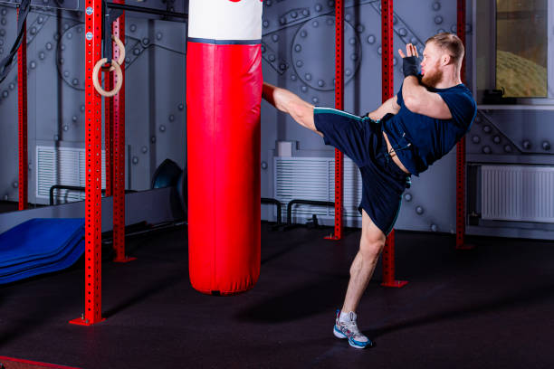 istock Mixed martial arts fighter inflicts powerful side kick on punching bag. 1454968732