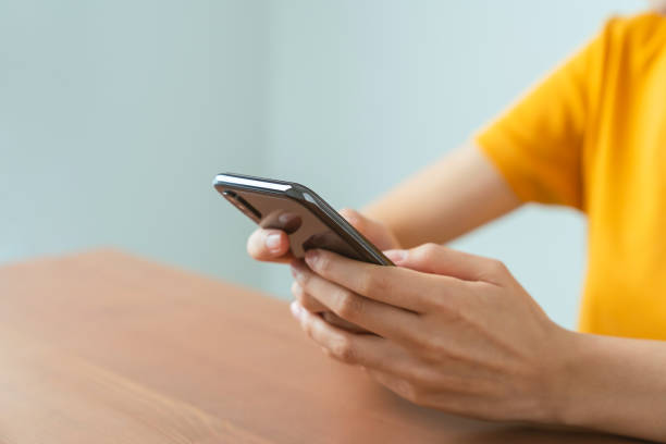 istock Hand holding smartphone with using social media on internet on sofa in living room. 1454968911