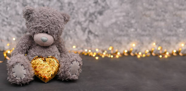 lindo oso de peluche con un corazón de oro. una tarjeta de felicitación. desenfoque selectivo - your text here fotografías e imágenes de stock