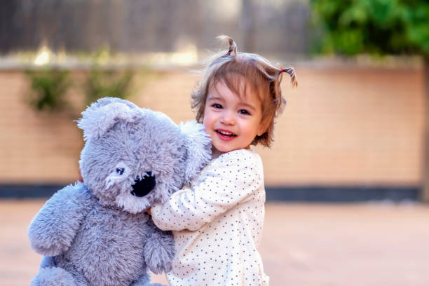 istock smiling girl hugging her teddy 1454969376