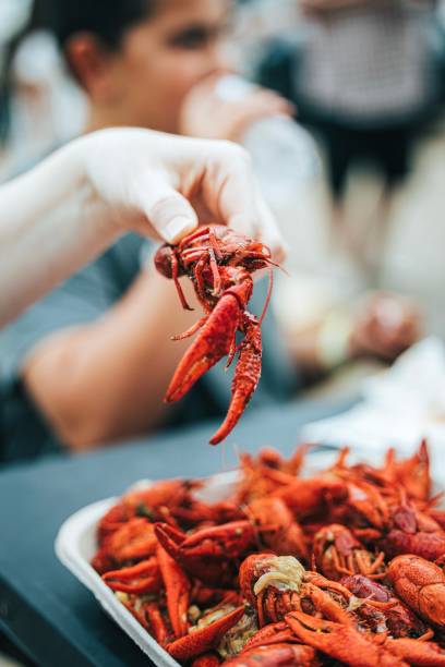 istock Vertical closeup of a person holding a fresh crawfish 1454969649